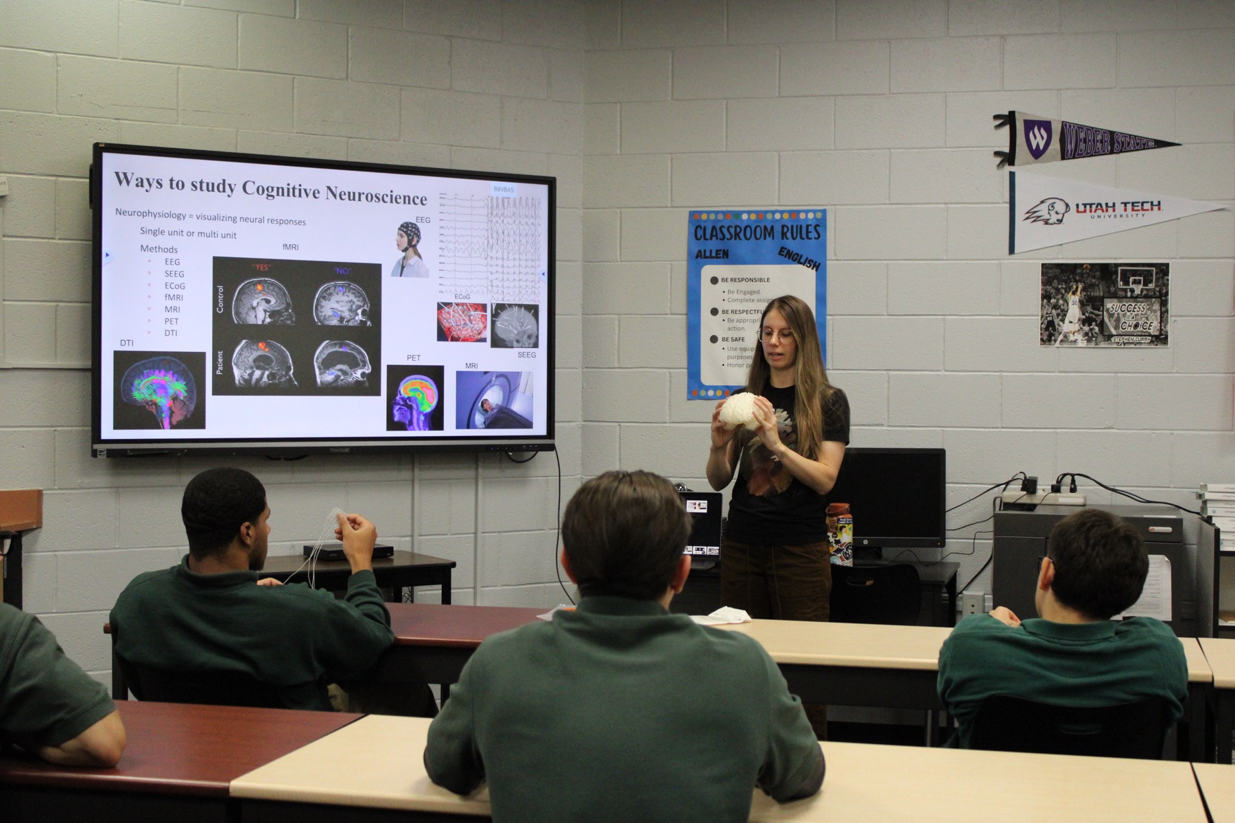 Martina Hollearn teaching a classroom about cognitive neuroscience, holding a model brain